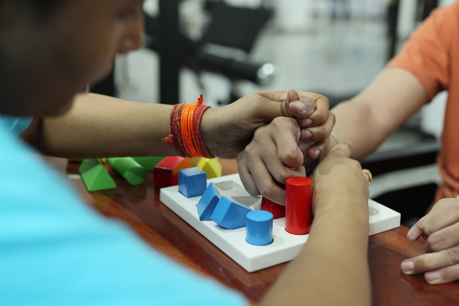 Occupational therapy at Neuranta, Sector 39 Gurugram — a therapist guiding a patient’s hand through a shape-sorting and pegboard task to rebuild grip and coordination