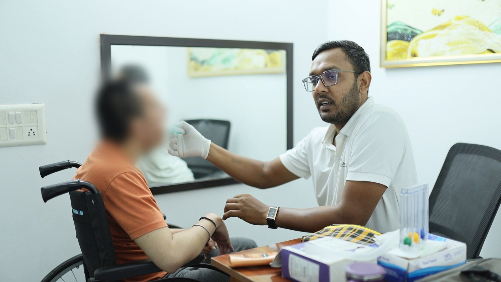 Speech therapy in Gurugram at Neuranta, Sector 39 — a speech therapist demonstrating a mouth movement for the patient to copy during oral-motor and articulation work, the patient seen in profile with the face blurred