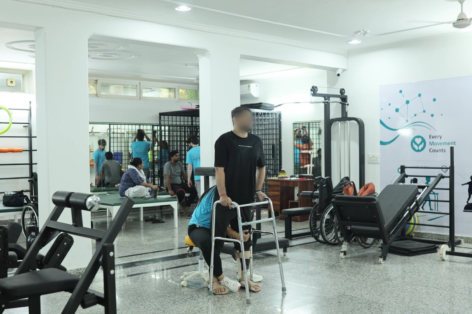 Gait training at Neuranta, Sector 39 Gurugram — a patient walking with a rolling frame while a physiotherapist supports from beside, in the main therapy gym